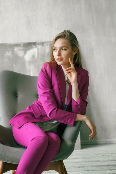 年轻的女商人。美丽的女人董事，主管，总经理，ceo在时尚明亮的商业粉色，紫红色的颜色西装在扶手椅上拍照。事业有目的有野心的女孩野心家图片下载
