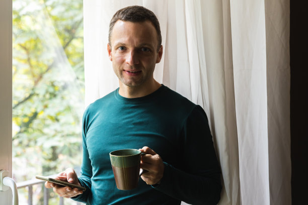 手里拿着咖啡和智能手机的男人图片下载