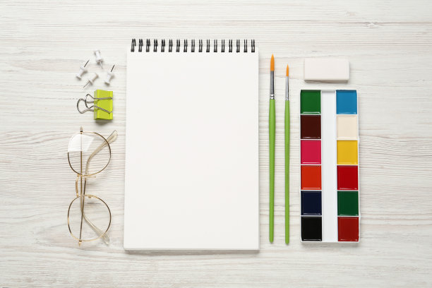 平铺构图与空白速写簿在白色木桌。空间的文本图片下载