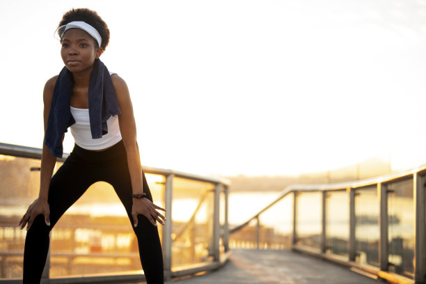 美丽的非洲妇女在训练后伸展。图片下载