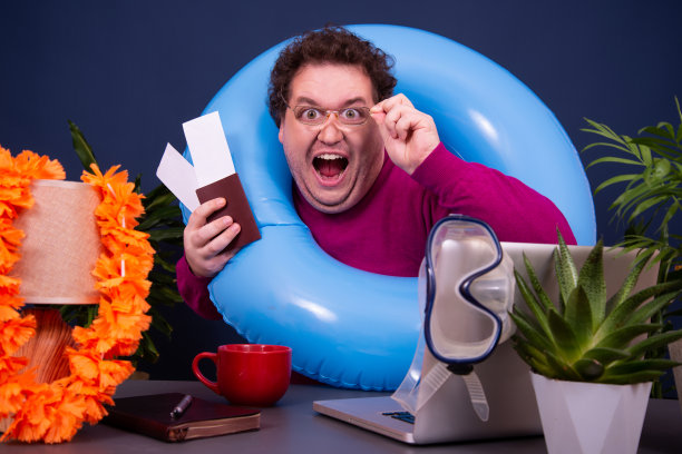 有魅力的男人在办公室工作，梦想着度假。图片下载