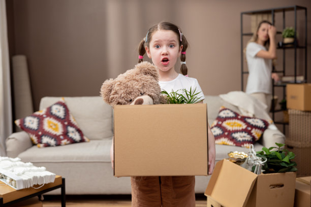 可爱的女孩在搬家时帮助她的父母，从房间里拿东西装在纸板箱里，搬箱子，搬进来，租公寓，房子图片下载