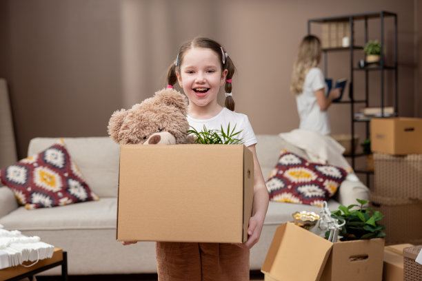 可爱的女孩在搬家时帮助她的父母，从房间里拿东西装在纸板箱里，搬箱子，搬进来，租公寓，房子图片下载