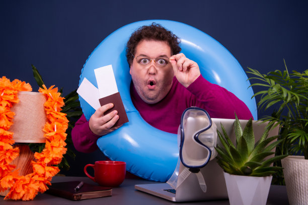 有魅力的男人在办公室工作，梦想着度假。图片下载