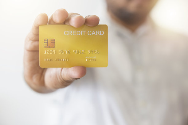 特写手的亚洲人拿着黄色的黄金信用卡在他的手。孤立的白色背景。金融、贸易、通信、社会、技术、商业的概念图片下载