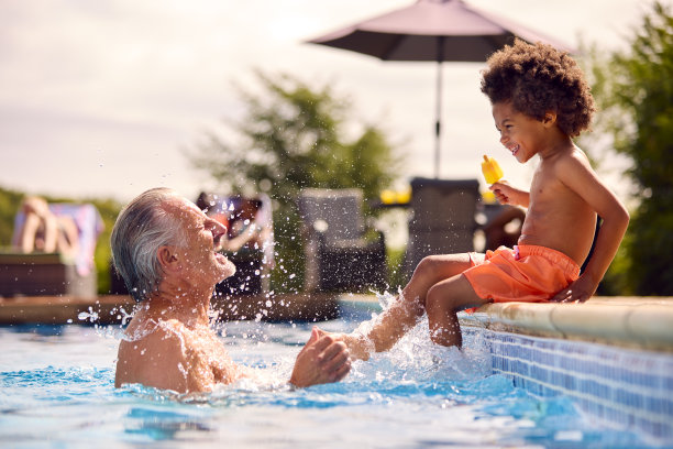 暑假，爷爷和孙子在游泳池边吃冰棍图片下载