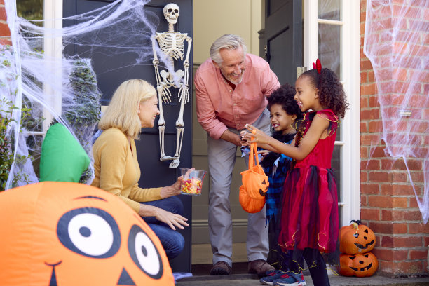 孙辈们盛装打扮，在万圣节去祖父母家玩不给糖就捣蛋的游戏图片下载