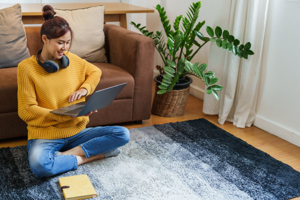 一个年轻的亚洲妇女在沙发上使用电脑的画像图片下载