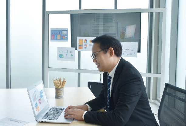 快乐的亚洲商人正在使用笔记本电脑图片下载