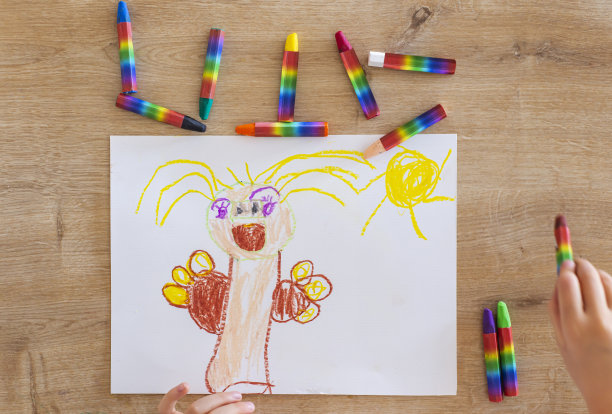 从鸟瞰图中可以看到家里的桌子和一个女孩正在用彩色蜡笔画画图片下载