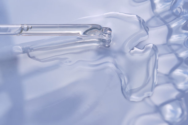 滴管与血清或化妆品油在蓝色的背景。图片下载