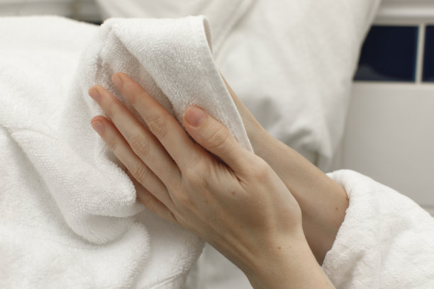在浴袍内用白毛巾擦干双手图片下载