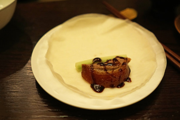 近距离烤蜂蜜北京烤鸭配中式煎饼卷，葱，黄瓜和甜豆海鲜酱图片下载