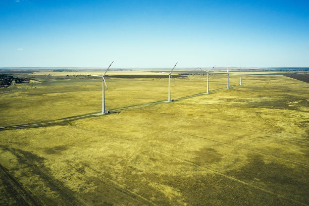 草原上的风力发电厂映衬着一架无人机拍摄的蓝天图片下载