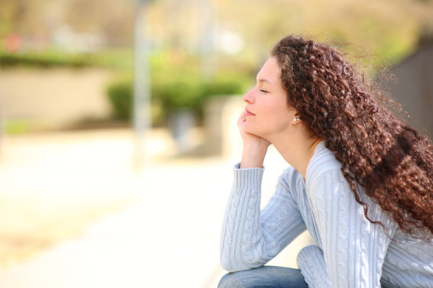 女子闭着眼睛在公园里休息和放松图片下载