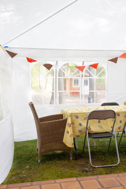 为聚会准备的帐篷里有一些五颜六色的旗子，还有一张桌子和一些不同的椅子图片下载