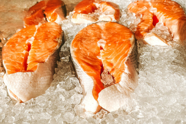 鱼市的冰柜台上躺着几块新鲜鲑鱼的生牛排。海鲜市场的露天货架。新鲜的红鱼，随时可以煮，昂贵的肉，冰凉的展示鱼图片下载