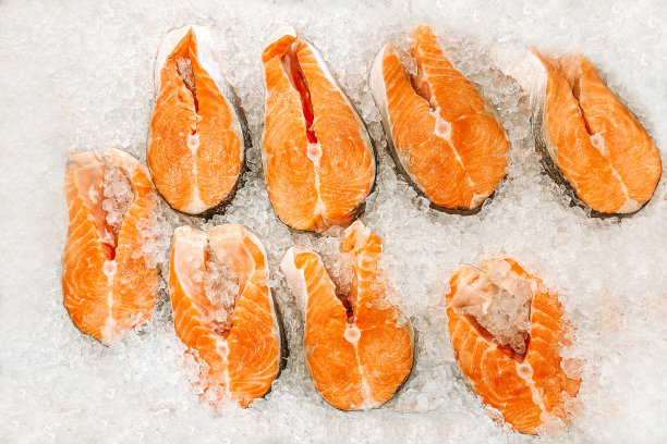 鱼市的冰柜台上躺着几块新鲜鲑鱼的生牛排。海鲜市场的露天货架。新鲜的红鱼，随时可以煮，昂贵的肉，冰凉的展示鱼图片下载