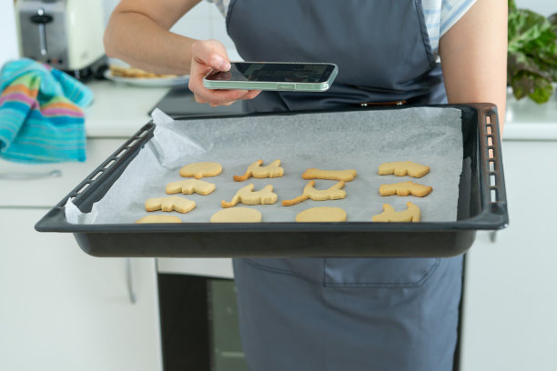 一名女子拿着托盘的万圣节饼干拍照。糕点店。副本的空间。图片下载