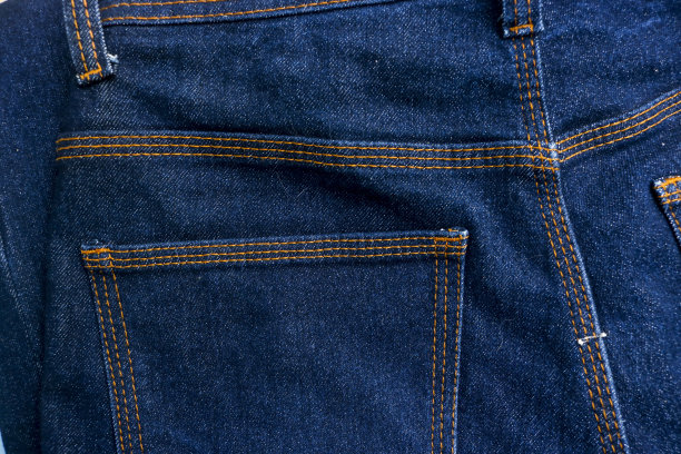 蓝色牛仔牛仔裤的后口袋与大量的橙色缝合图片下载