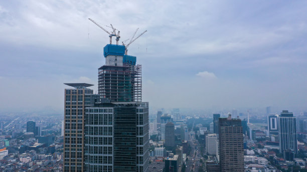 使用起重机建造多层的高层摩天大楼。这座建筑是贸易和商业中心的工作场所。双塔式建筑图片下载