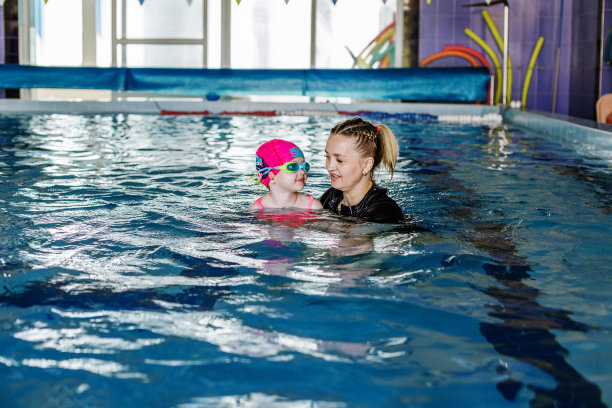 孩子在泳池学习游泳，游泳教练教学龄前儿童游泳图片下载