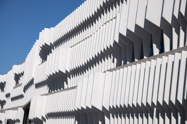 未来主义的部分建筑设计上清晰的蓝天背景。抽象的外观设计。现代城市建筑中的玻璃和金属。现代建筑外观。建筑行业。抽象。图片下载