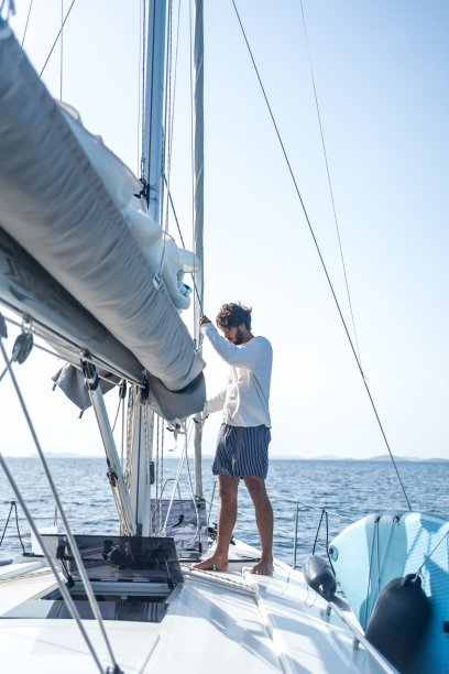 年轻人在海上用桅杆准备起航图片下载