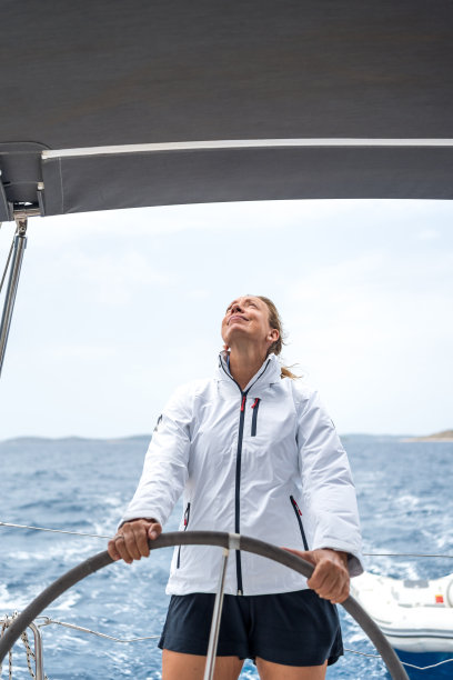 成熟女子在海上驾驶帆船图片下载