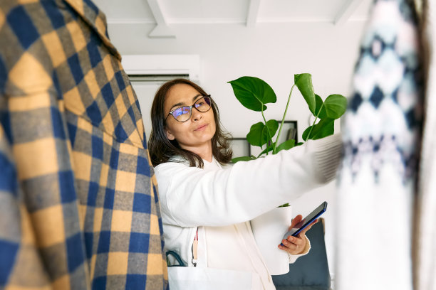 快乐的女人在商店买新衣服。针织毛衣挂在衣架的衣架上。慢时尚。有意识的消费。车库甩卖，再利用衣物，二手和生态消费理念图片下载