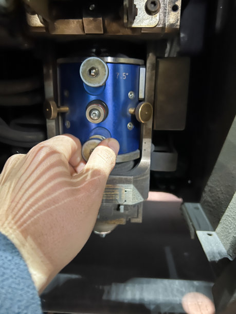 一个无法辨认的人的手的垂直特写，调整和调整镜头，在冶金工业的数控激光切割机上进行精确切割。图片下载