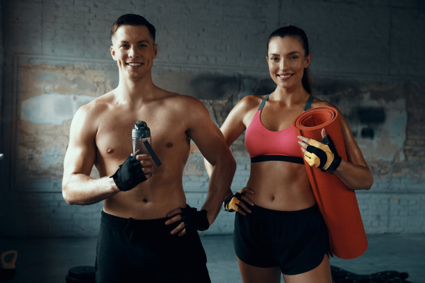 一对幸福的情侣一起站在健身房看着镜头图片下载