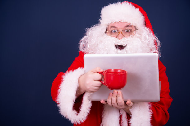 圣诞老人在网上看新闻。图片下载