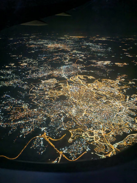 从飞机窗口拍摄的城市夜景的垂直照片图片下载