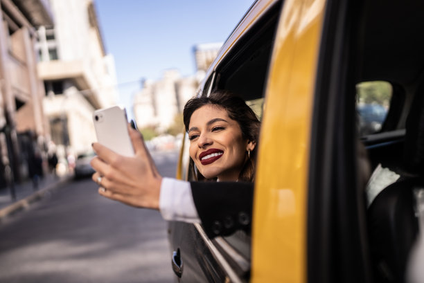 在出租车上用手机拍摄风景的年轻女子图片下载