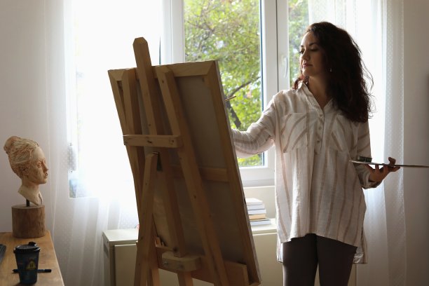 一个女人在家庭画室画画。图片下载