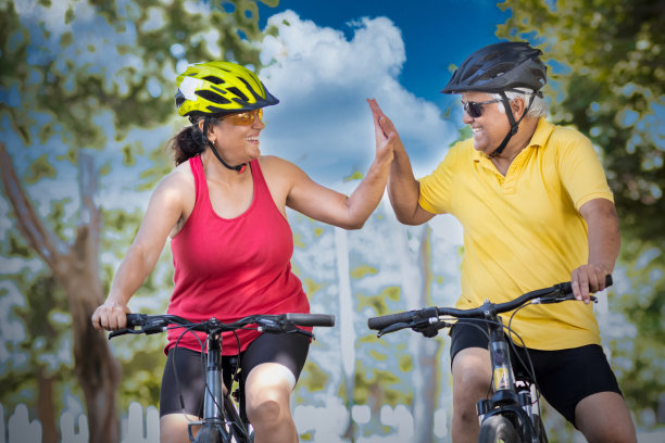 活跃的老人和妇女在骑自行车时击掌庆祝图片下载
