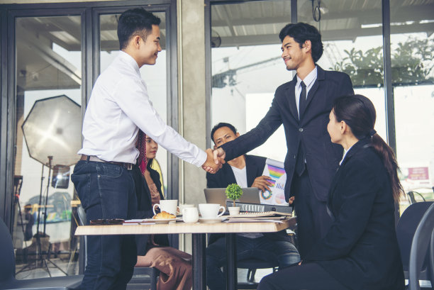 团队合作伙伴握手问候在会议室开始小生意。在现代办公室里，团队合作伙伴握手。企业并购图片下载