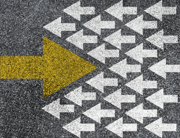 不同的思维和商业和技术颠覆的概念。在沥青路面上，黄色大箭头与白色箭头方向相反。图片下载