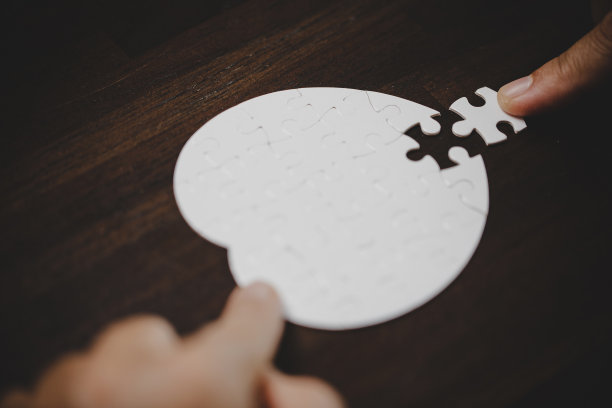 商业女性手拼图的策略和解决方案的想法。特写部分的两个白色拼图连接在一起。加入合作理念，成功团队，问题团队。图片下载