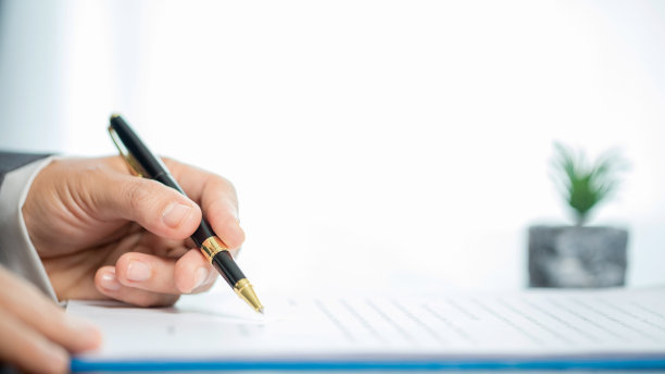 职场特写人物职业女商人坐在桌子前拿着笔签署或签署合同文件。女员工在办公室用书面形式写公司协议文件图片下载