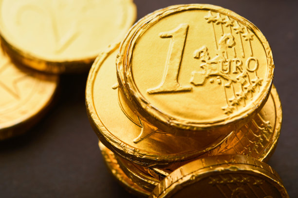 巧克力的硬币。背景巧克力欧元硬币钱的棕色背景。欧元硬币以不同的位置堆叠在一起。的硬币。模拟。图片下载