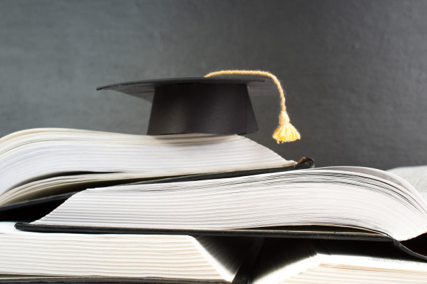 打开书在木制甲板桌和黑色的板背景。回到学校。教育概念与复制空间为您的广告文本。图片下载