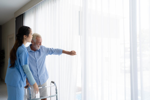 老年男性患者与护工进行物理治疗。图片下载