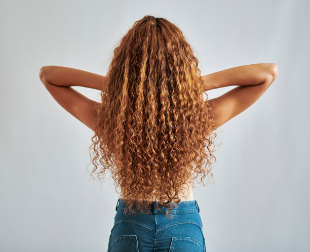 自然，模型和卷头发的妇女背部姿势为头发护理运动与模拟的背景。女孩与健康，光泽和波浪纹理弯曲的美容处理与白色工作室墙壁。图片下载