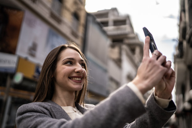 年轻女子在街上用手机自拍图片下载
