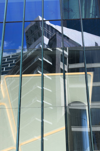 建筑物在另一幢建筑物的窗户上倒映。图片下载