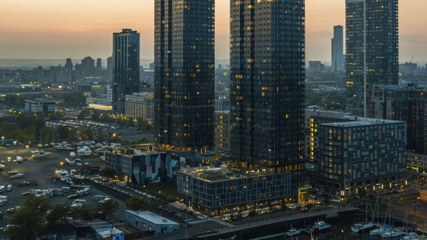 泽西城的现代公寓，在夜晚灯火通明。前面是停车场，后面是住宅区的富裕住宅公寓。图片下载