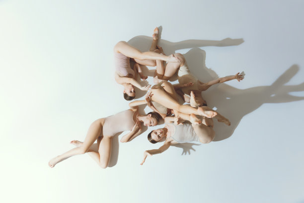 一群年轻的女孩，芭蕾舞者表演，摆姿势孤立在灰色的工作室背景。混乱。俯视图图片下载