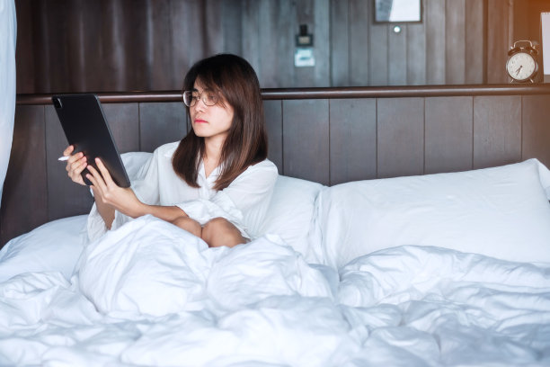 快乐的女人用平板电脑视频通话，快乐的女人在床上用电脑开会。技术、网络、在家工作、生活方式和数字沟通概念图片下载